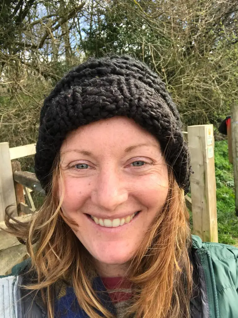 Clare pictured smiling in a black beanie hat