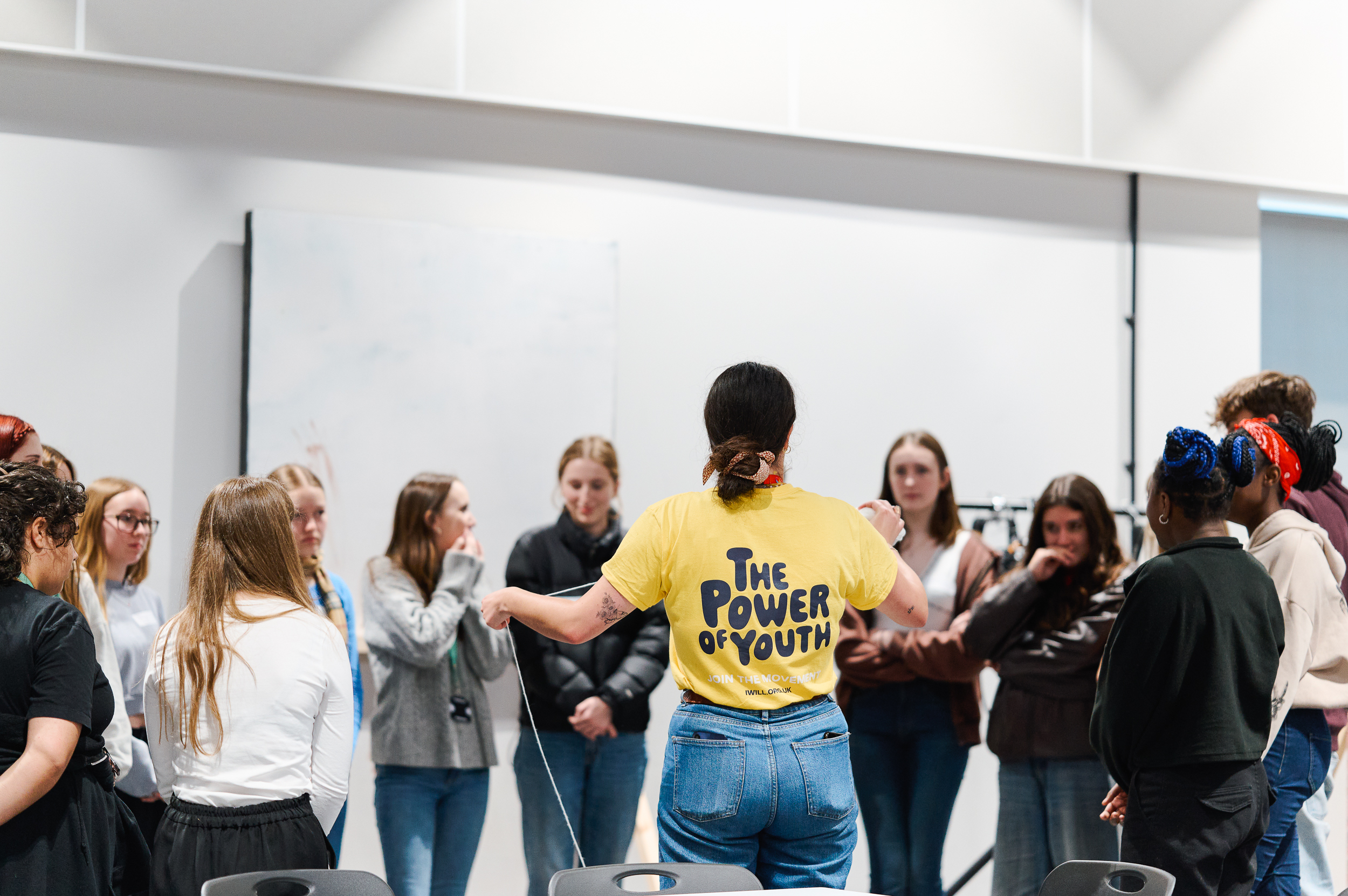 A group of young people standing in a discussion group.