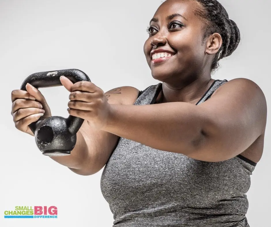 Female holding a kettle bell weight in front of her