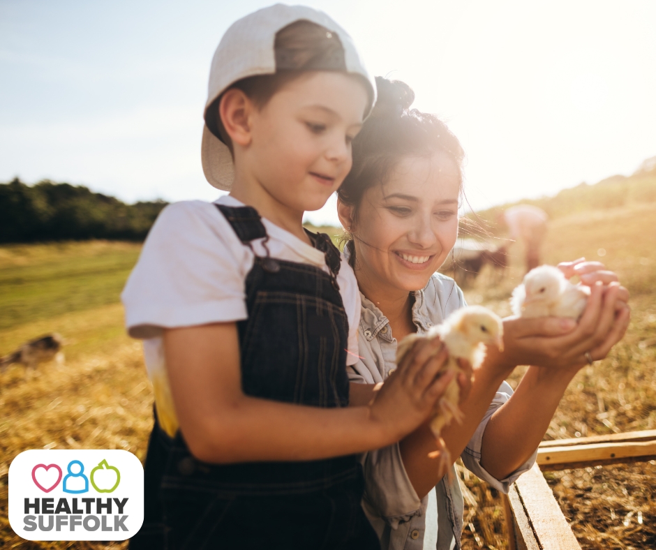 Mother and child holding chicks at the farm