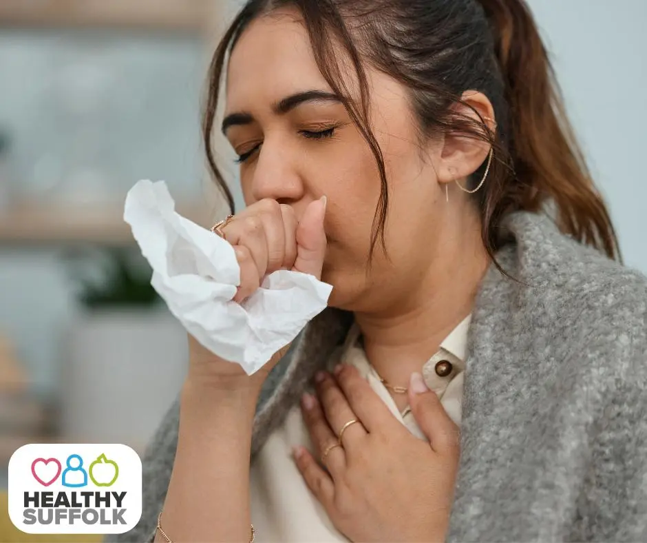 Woman coughing into a tissue