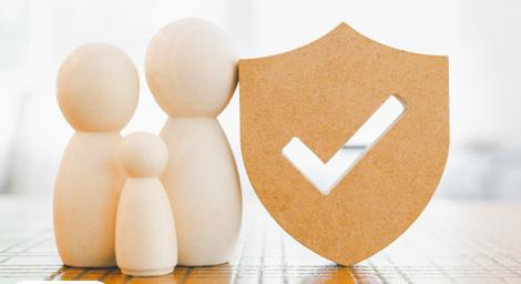 Models representing a family pictured with a crest that has a tick inside it.