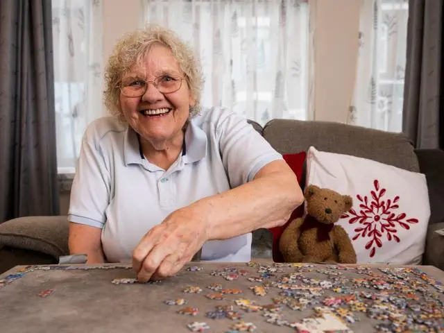 Older women smiling whilst completing a puzzle