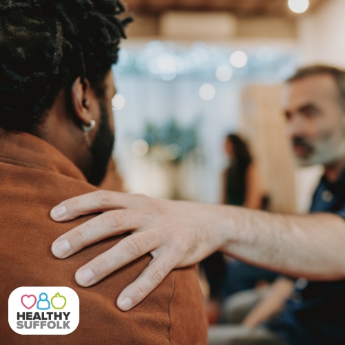 Man holding another man's shoulder offering support
