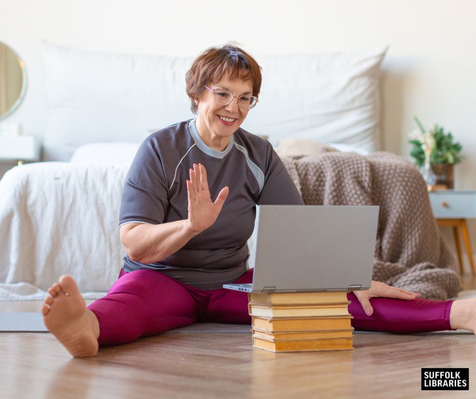 Middle aged woman following an online exercise class